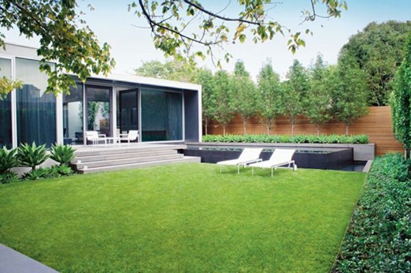 lounge stoelen en groen gras in de grote achtertuin van een luxe huis