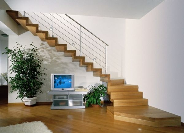 fritt flytende trapp i stuen med grønne planter og en TV