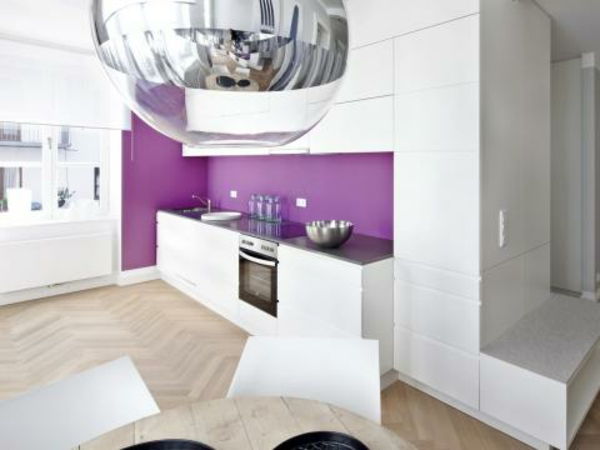 biele skrinky a fialová stena v modernej kuchyni