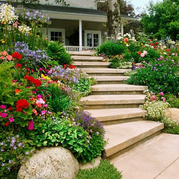 Modernūs namai-dizainas-laiptai iš akmens sau pastatyti daug gėlių ir žalių augalų