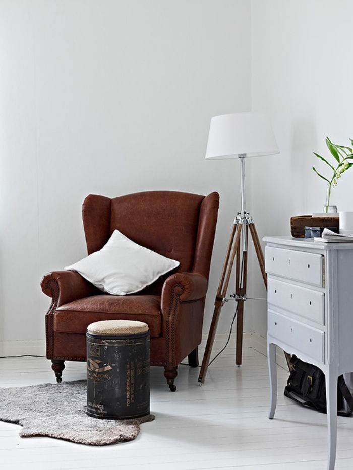Vintage baldai, svetainė, interjero dizaino idėjos, ruda odinė sofa su balta dekoratyvine pagalve, grindų lempa ir stalčius