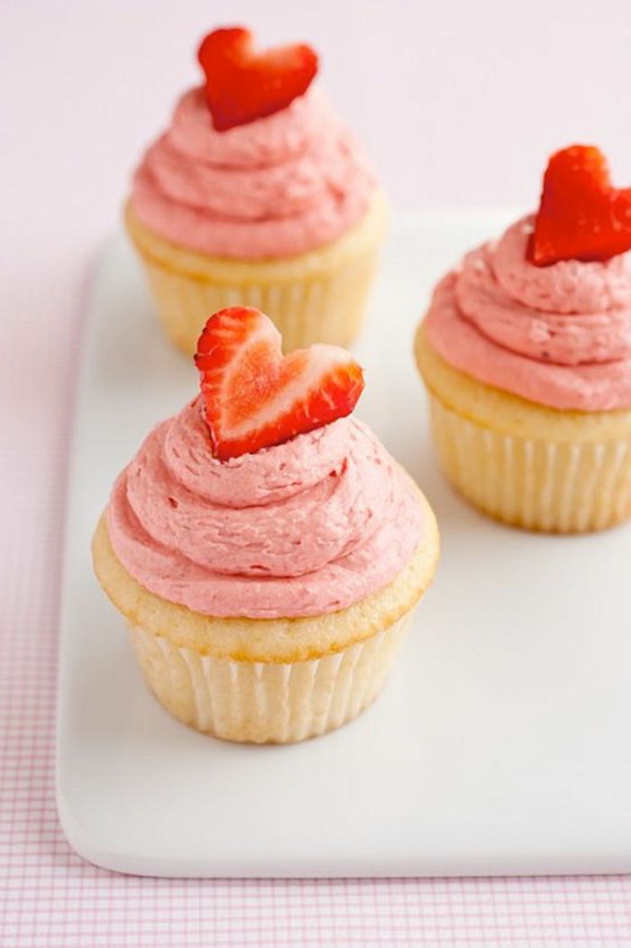 muffins dekorert med rosa krem ​​og jordbærhjerter
