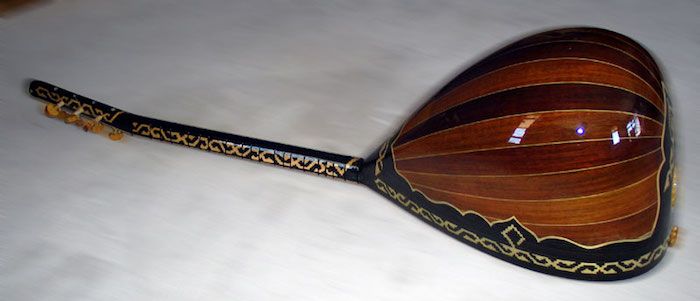 en bouzouki från ryggen, tillverkad av individuella träbrädor med olika nyanser av brun färg, kanter med guldfärg dekoration