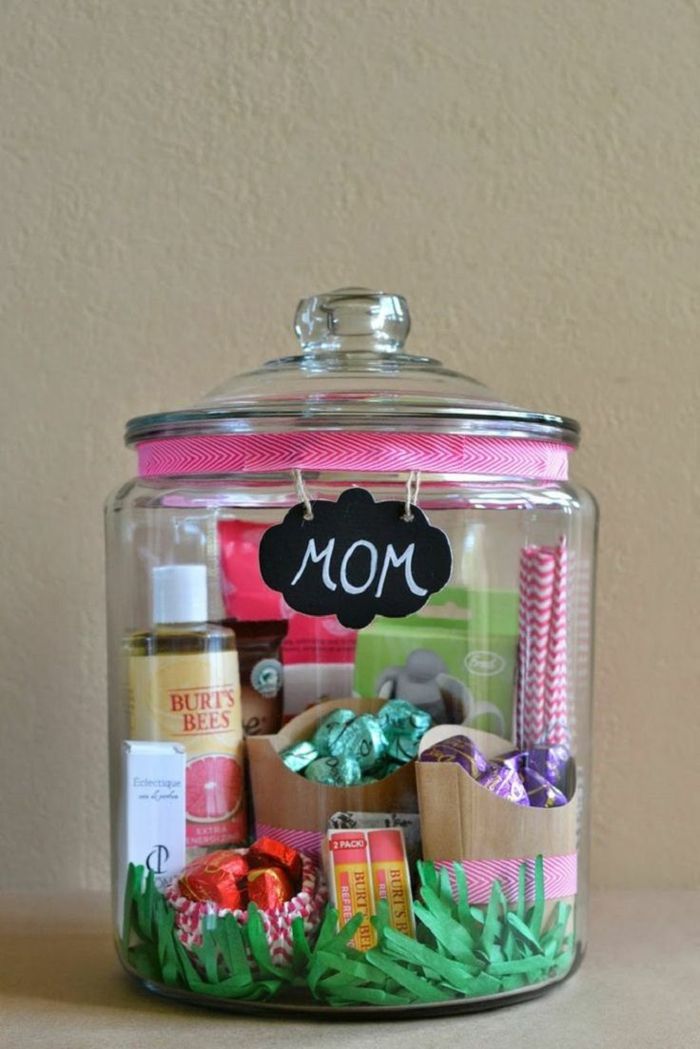 en mason krukke full av søtsaker og kosmetikk med rosa bånd og en bord gaver til mors dag
