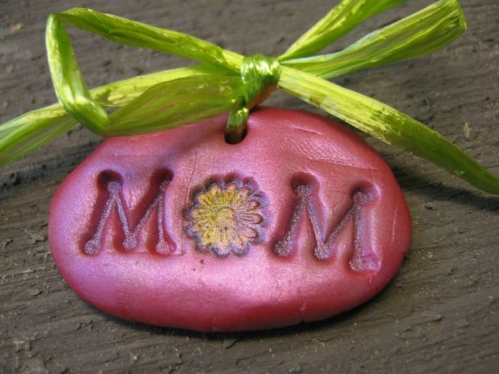 Mum på rosa bakgrund. Skriven med blomma för brev och grönt band