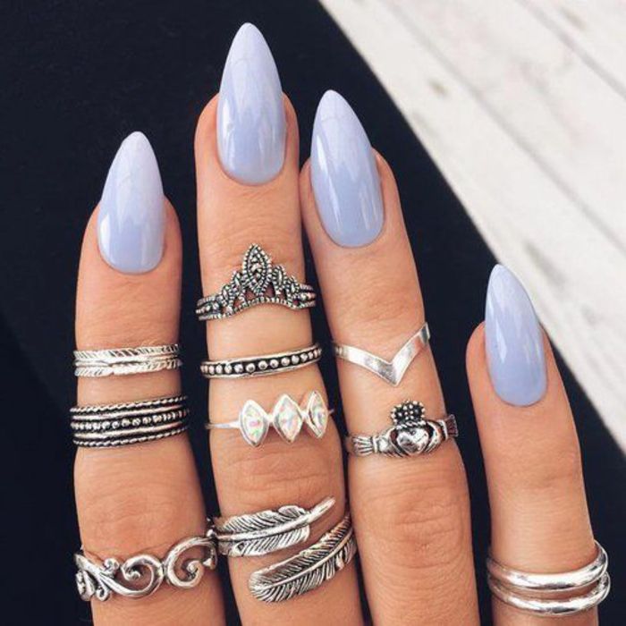 unghie affilate in un design sottile ed elegante e un bel colore viola combinato con molti anelli