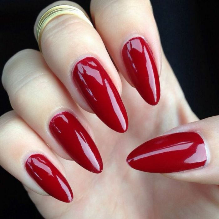 unghie gel a punta in colore rosso elegante lucente bello con anelli dorati combinano grandi idee femminili