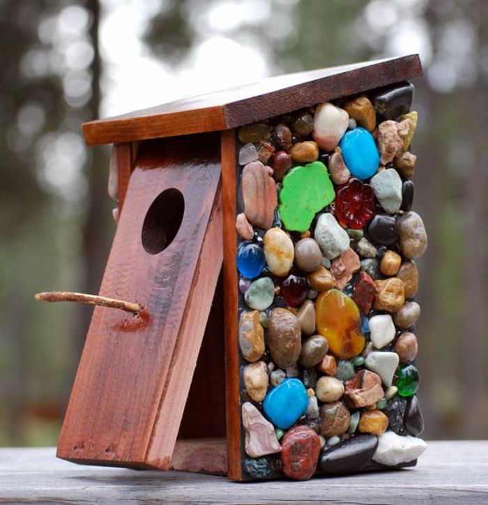 Drewniana budka gniazdowa z kolorowymi kamieniami ozdobnymi, budkami dla ptaków i piękną dekoracją ogrodu lub balkonu w tym samym czasie