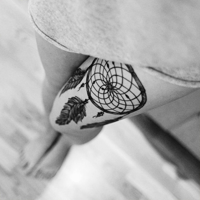 Her viser vi deg en ide for en svart tatovering på beinet - en liten, vakker svart drømfanger med fjær