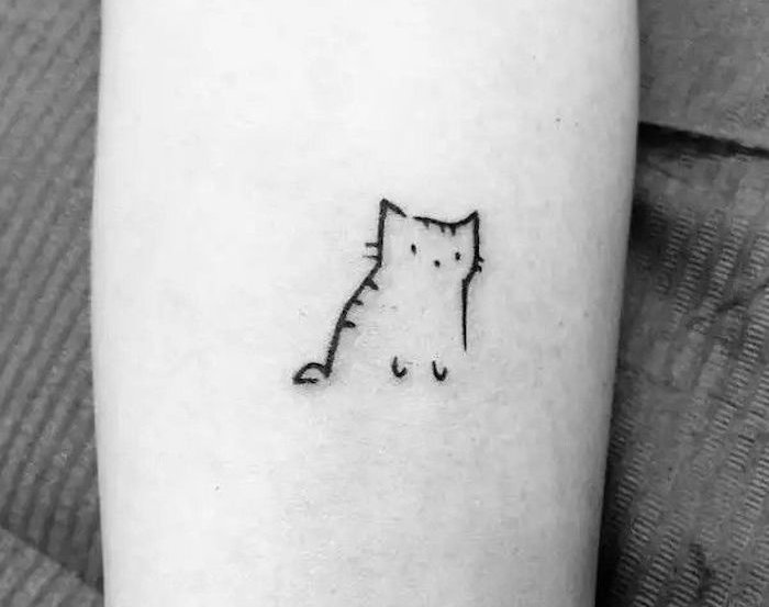 o mână cu un tatuaj mic de pisică neagră - aici este o pisică cu ochi negri și vibrissen