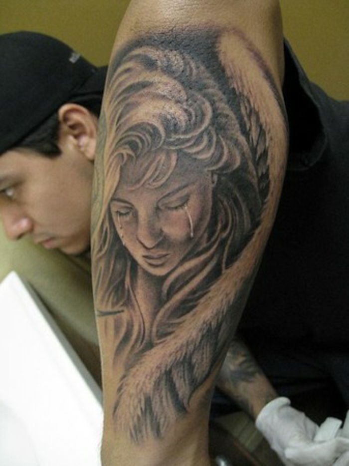 een trieste en huilende vrouw met grote engelenvleugels met witte veren - idee voor een tatoeage-engel voor de mannen