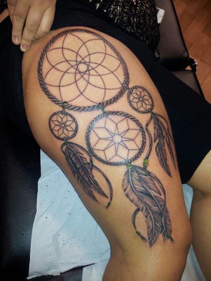 Tattoo på benet av en kvinne med en stor, vakker svart drømfanger med stjerner og lange svarte fjær