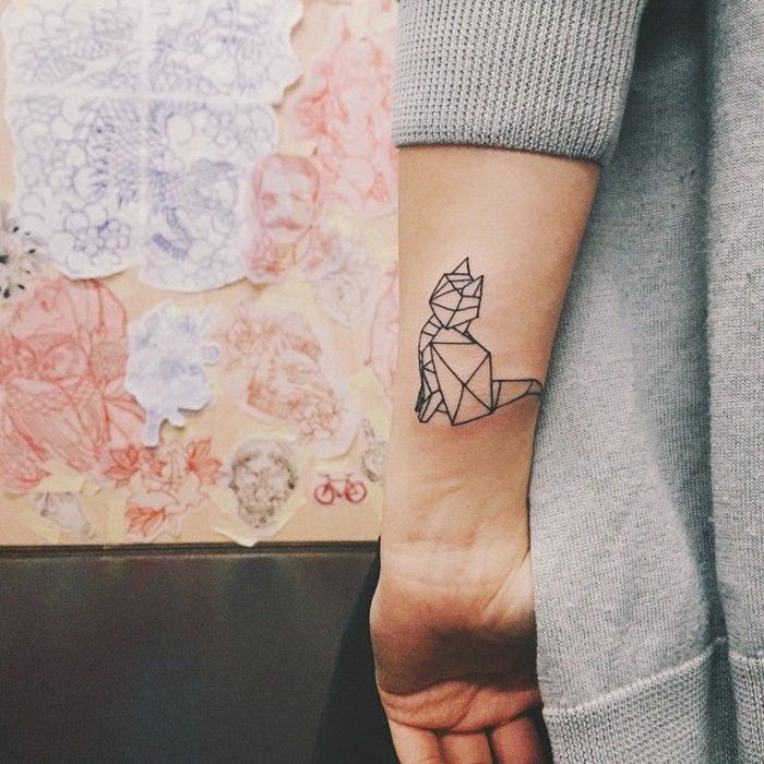 o mână cu un tatuaj mic de pisică neagră - idee pentru un tatuaj pentru femei