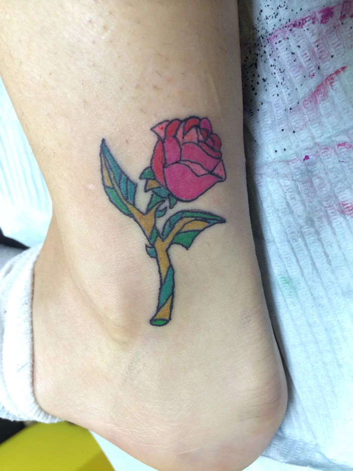 spójrz na ten mały tatuaż na kostce - pomysł na czerwoną różę z zielonymi liśćmi