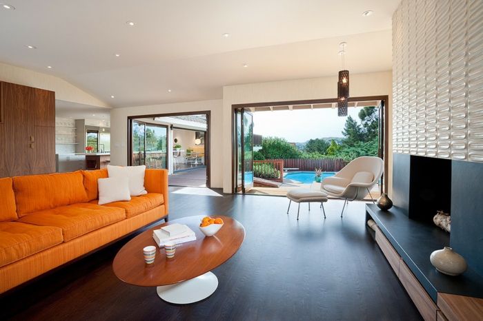 öppen härd-vägg kakel-laminat-dark-träpanel-orange-soffa-oval-table-pool-trädgård