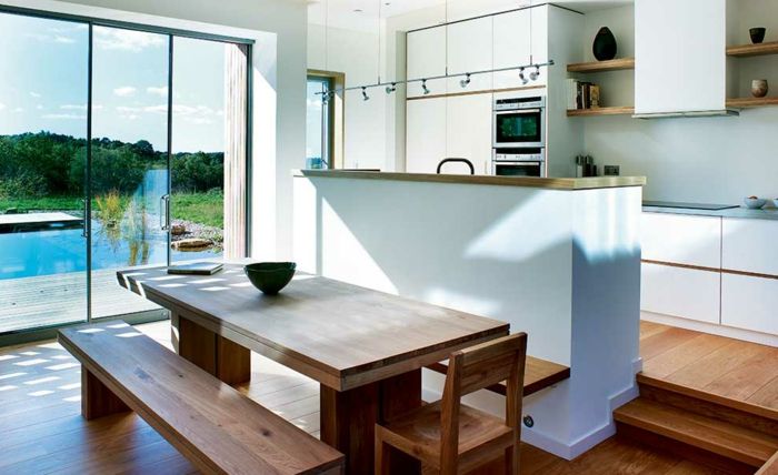 otvorenú kuchyňa s-counter-drevená podlaha-schodisko-jedálenský stôl a drevená lavica drevo, drevené stoličky-bielo-kuchyňa frontoch výhľadom na bazén