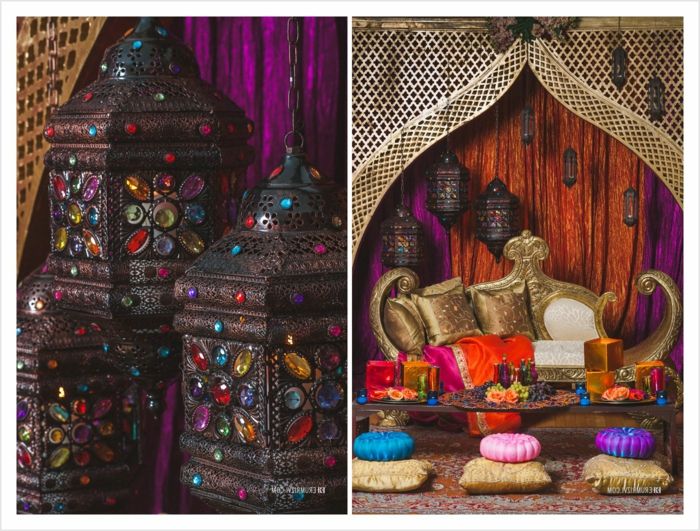 Trys dekoratyviniai žvakidės pagamintos iš metalo su mažais spalvingais kristalais, metalo liustra su daug papuošalų, foto koliažas iš dviejų vaizdų, dizainerio sofos su pagalvėmis aukso spalvos, mažo stiklo stalas su turtinga apdaila, šešių sėdynės, apvalios pagalvėlės trijų skirtingų spalvų, sienų danga su drožyba, oranžinės ir violetinės sienos užuolaidos