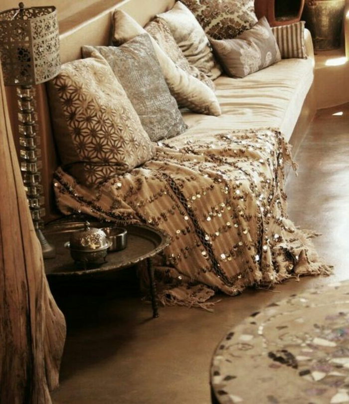 idee deco orientali per progettare un divano dalla coperta lucida con molti cuscini colori tenui nella stanza beige