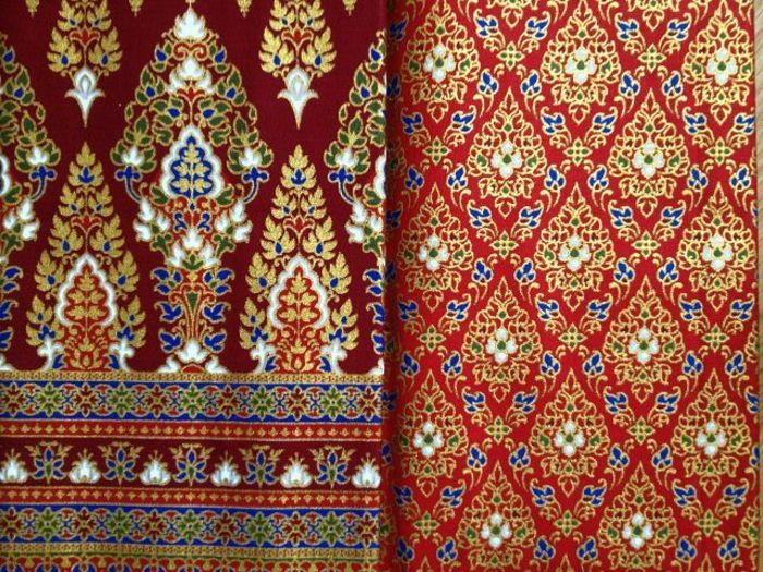Tkaniny z różnymi nadrukami w odcieniach czerwieni z niebieskim, żółtym i zielonym wykończeniem