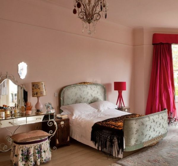 orientalsk soverom med en vakker seng med hodegjerde og gardiner i cyclamen farge