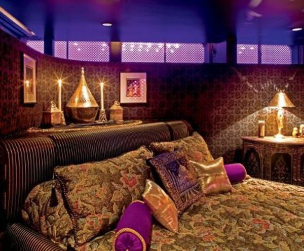 ljus och lyxig säng med många färgstarka kuddar för en elelantes design av det orientaliska sovrummet