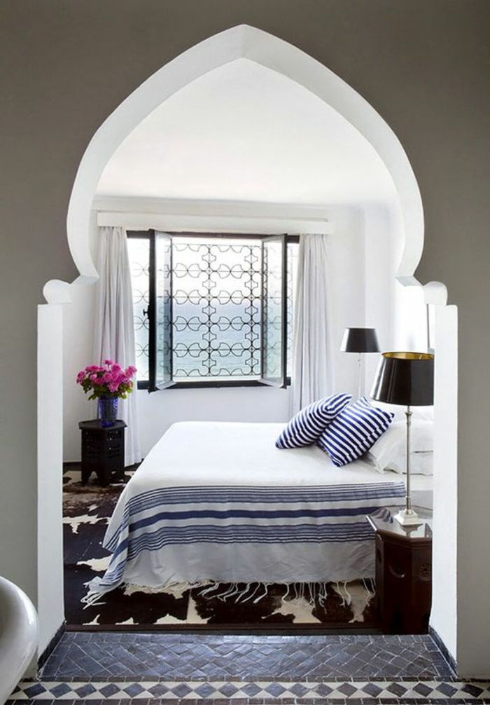 orientaliska möbler sängtäcke vit och blå golvlampa blommor i vas deko lila rostfönster med gitter