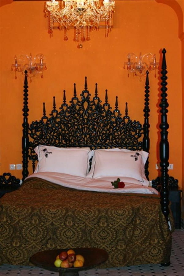 Aristokratiskt snygg huvudtavla i lyxigt orientaliskt sovrum med orange väggdesign
