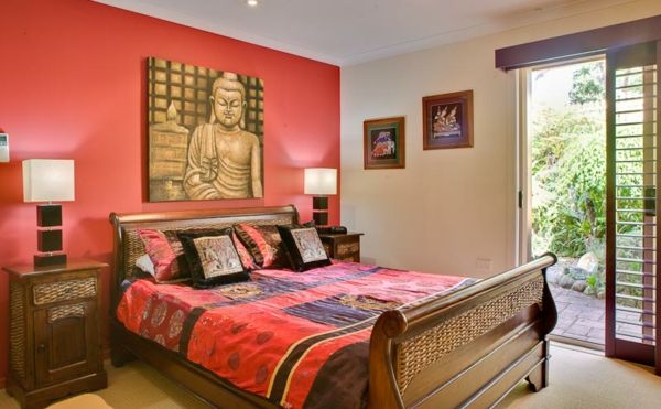 Peachy röd som en primär färg för ett asiatiskt sovrum med buddha målningar