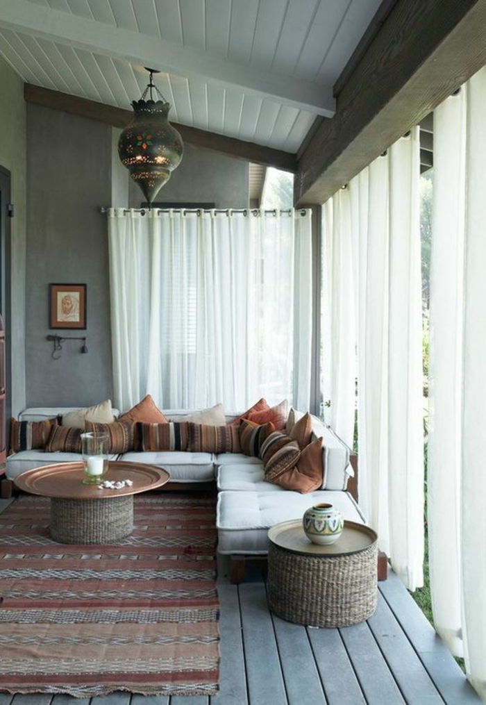 rytietiškas kambarys veranda užuolaidos dėklas kavos staliukas sofos pagalvėlės įvairios dekoracijos paveikslėlis ant sienos