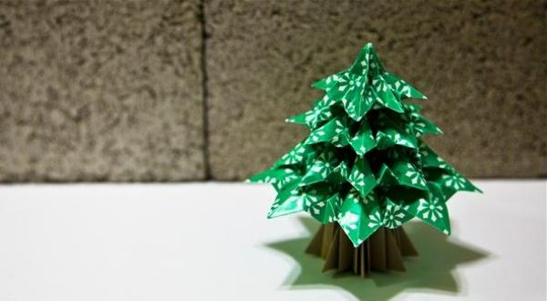 origami-till-jul-gran-träd-i-grön-färg - framför en vägg