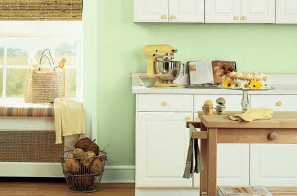 Lepo oblikovana majhna kuhinja - bele omare združujejo z leseno mizo