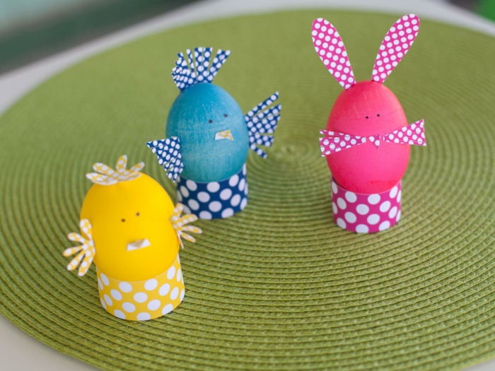tre forskjellige egg i gule, blå og rosa farger som dyr