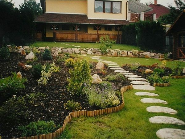Steinplatten voetpad en groene planten in de prachtige tuin van een gezellig huis