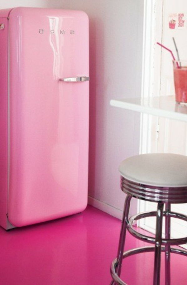 Sweg kjøleskap i rosenrød farge-en bar stol ved siden av den