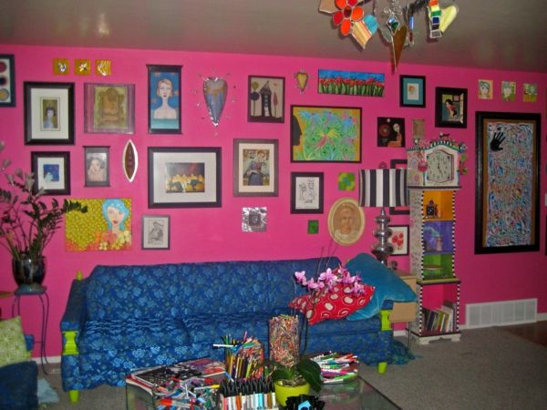 roz-perete-vopsea-și-multe-imagini-pe-perete-canapea în albastru