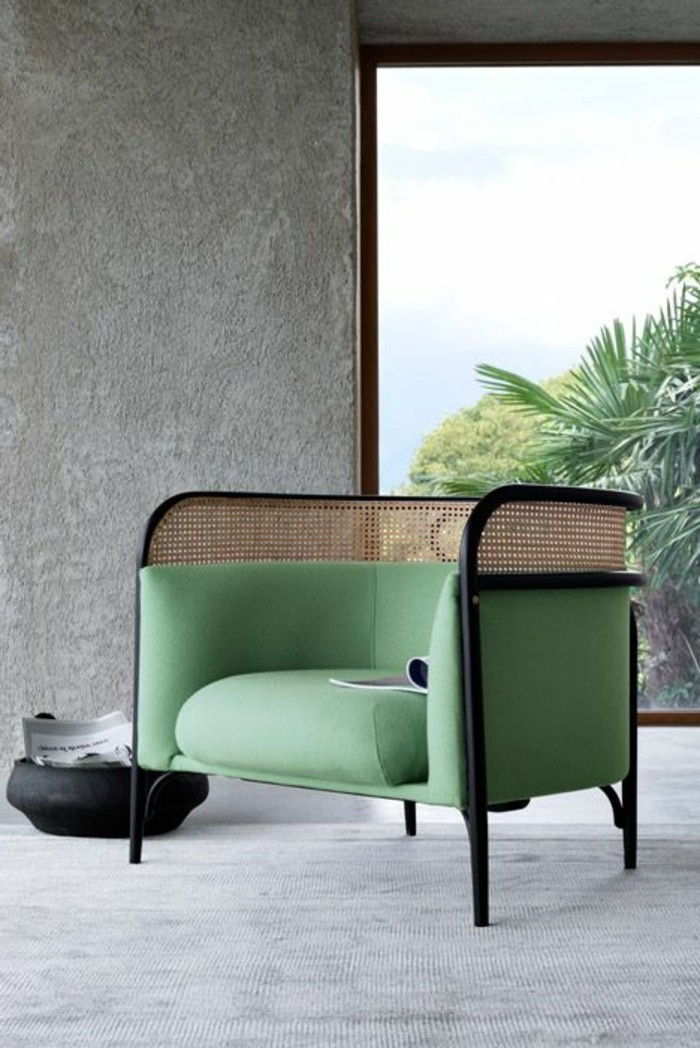 Polstermoebel-guenstig-minimalista-sedia-verde-bianco-vimini-tappeto-muro di pietra