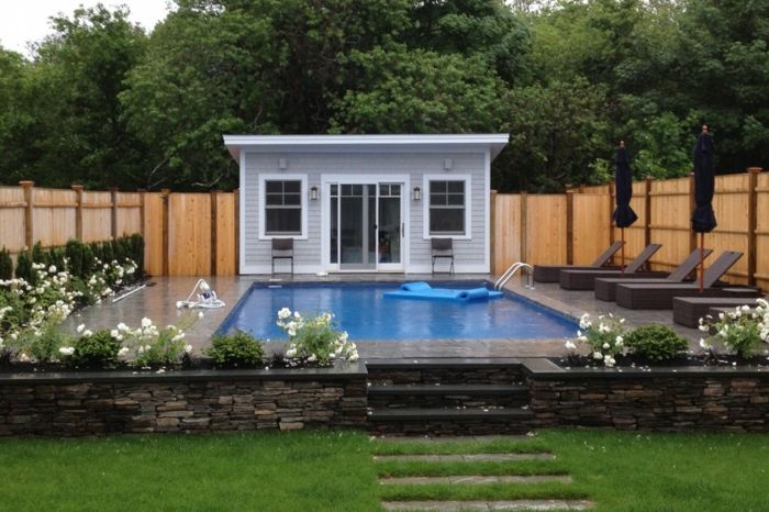 Önünde büyük bir yüzme havuzu ile küçük bir ev - modern ön bahçesinde