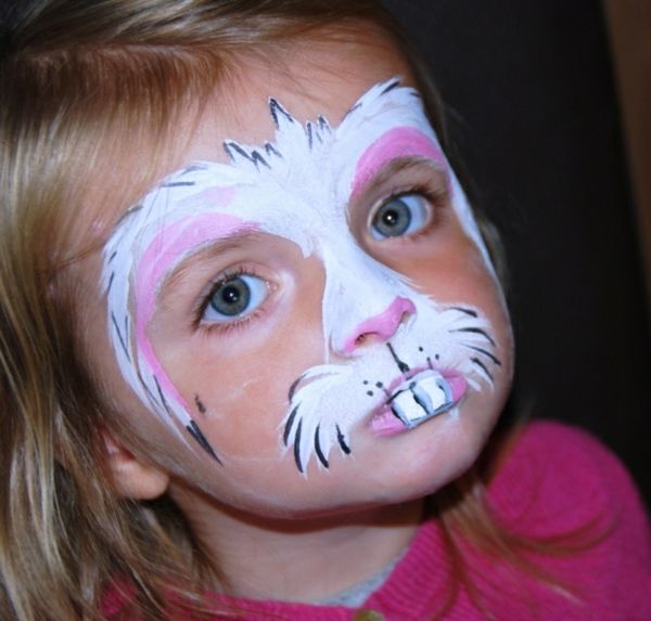 måla kanin ansikte - en liten tjej med ljusa ögon