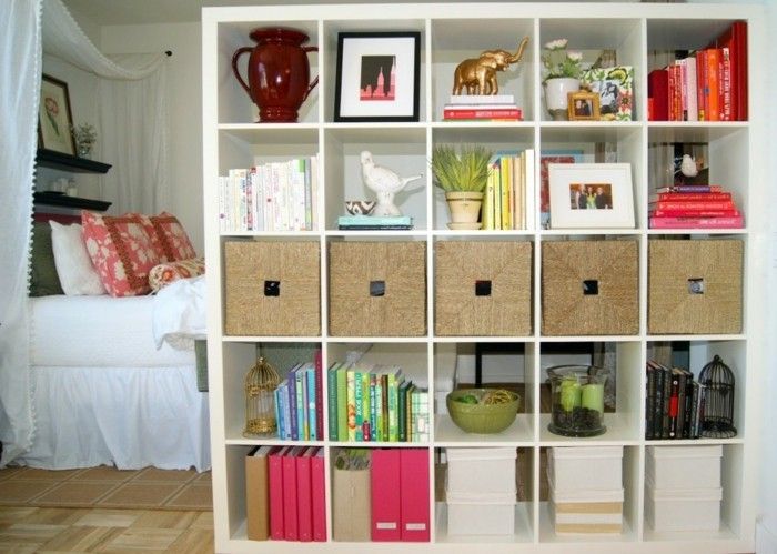 rumsavdelare-shelf-hyllan-utrymme Trenner-partition-shelf-böcker hylla-rumsavdelare sovrum trä golv dubbelsäng färgglada kuddar