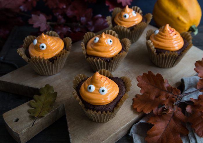 Pečenje Halloween, pečenice okrašene z oranžno kremo in čokoladnimi očmi