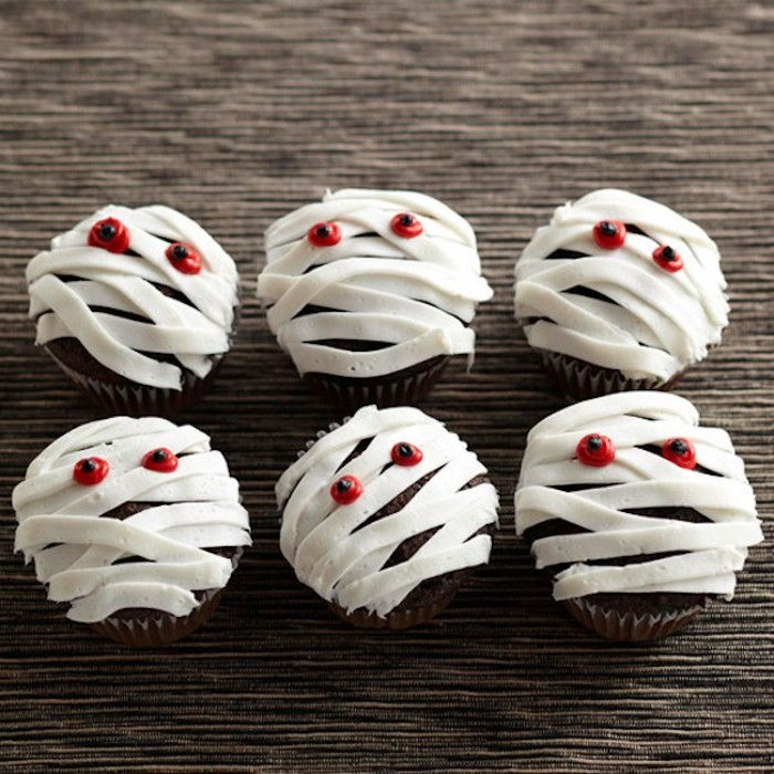 Dia das Bruxas assando, múmias de cupcakes com olhos vermelhos, decorando cupcakes