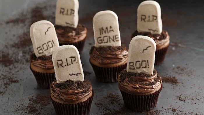 Cozimento de Halloween, sepulturas de muffin decoradas com chocolate e fondant