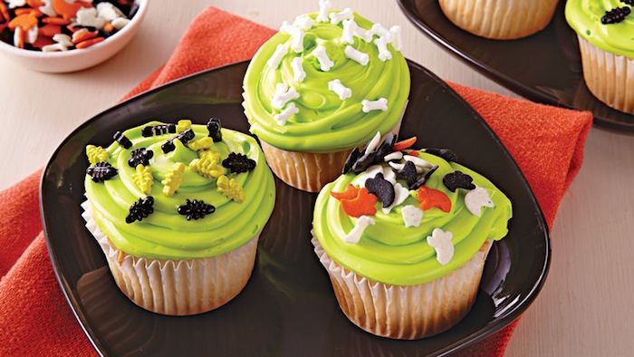 halloweenbakning, vaniljmuffins med grön kräm och lilla fondantfigurer