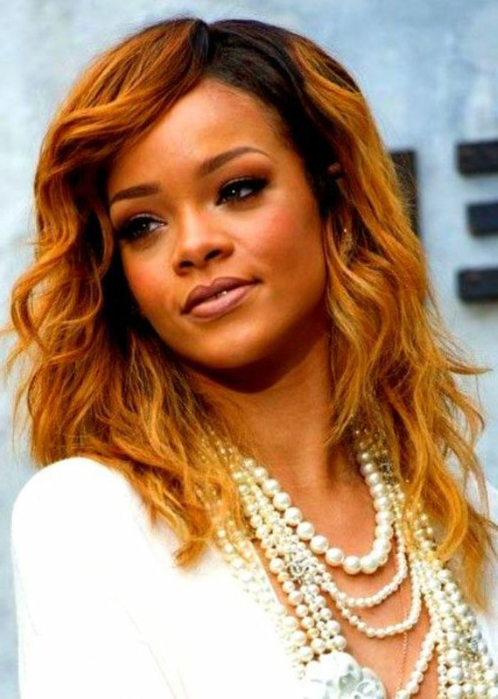 Olhar de sonho no rosto de Rihanna - penteado encaracolado vermelho - cabelo Rihanna