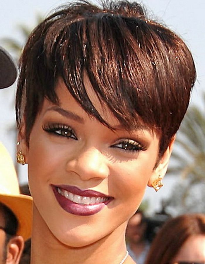 Cabelo curto Rihanna um sorriso tentador, batom rosa e brincos de ouro