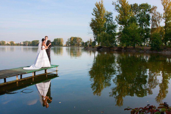 romantiška vestuvių fotografija nuotaka ir jaunikis ant krantinės
