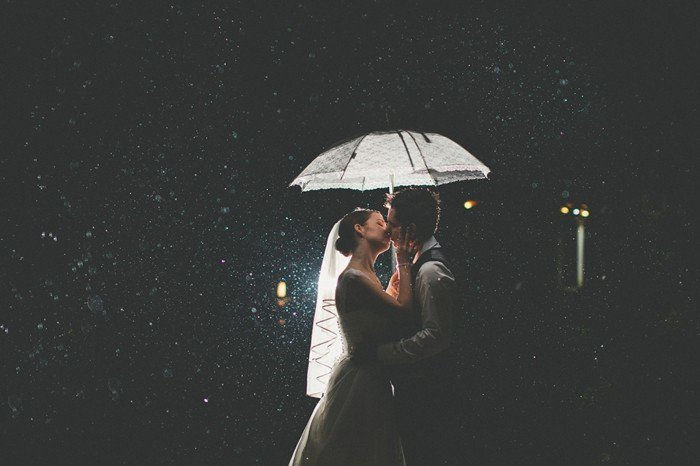 romantiška vestuvių nuotrauka nuotaka ir jaunikis pabučiuoti per lietų