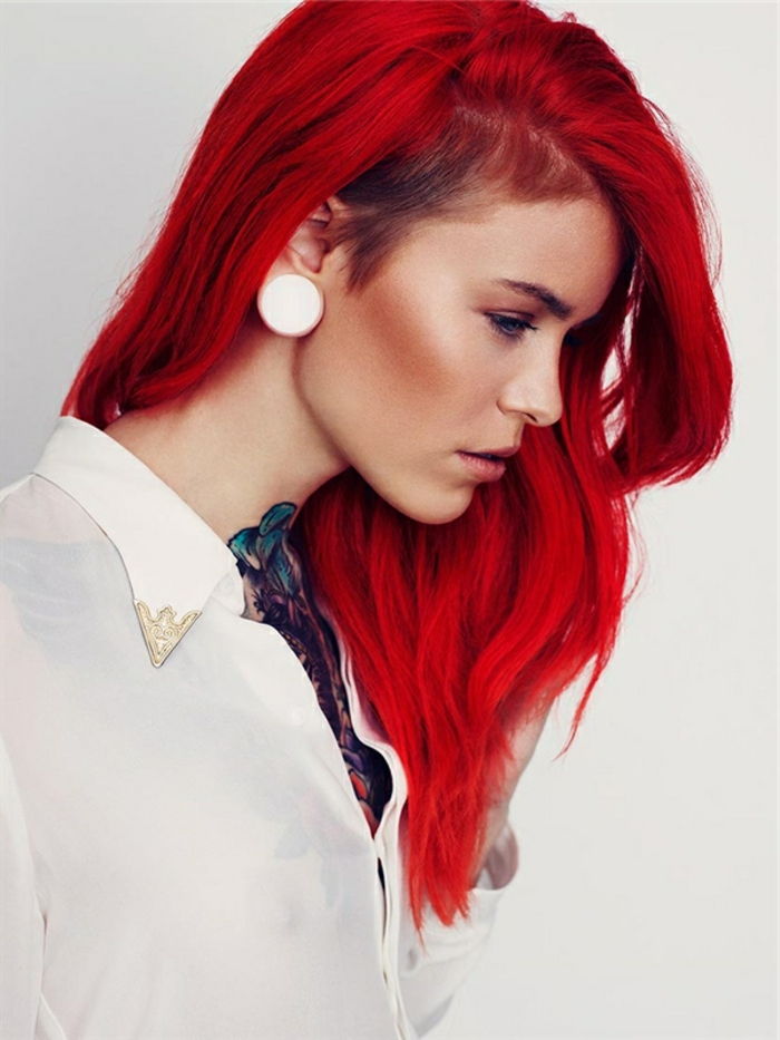 intensyvūs raudoni plaukai, balta marškinėliai ir balti auskarai, spalvota tatuiruotė, graži moteris