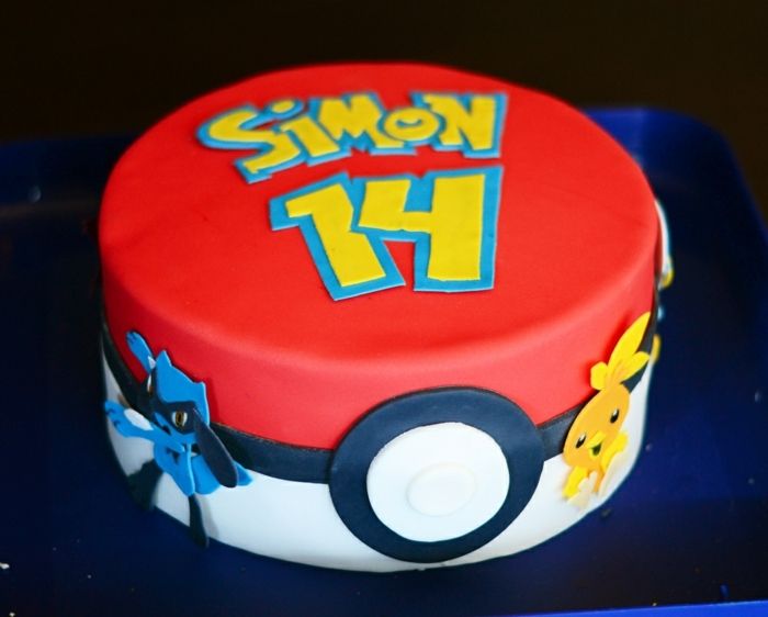 torta di compleanno pokemon - un'idea per una grande torta pokemon rossa che sembra una pokeball rossa, con titoli gialli e due piccole creature pokemon