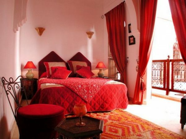 stor seng i soverommet med røde fargeskjemaer